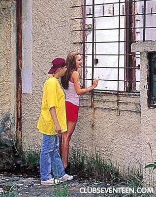 Sandy et un ami dehors avec des godes et des jeans déchirés.