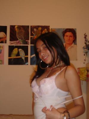 Latina super linda en la cama de rodillas en sujetador